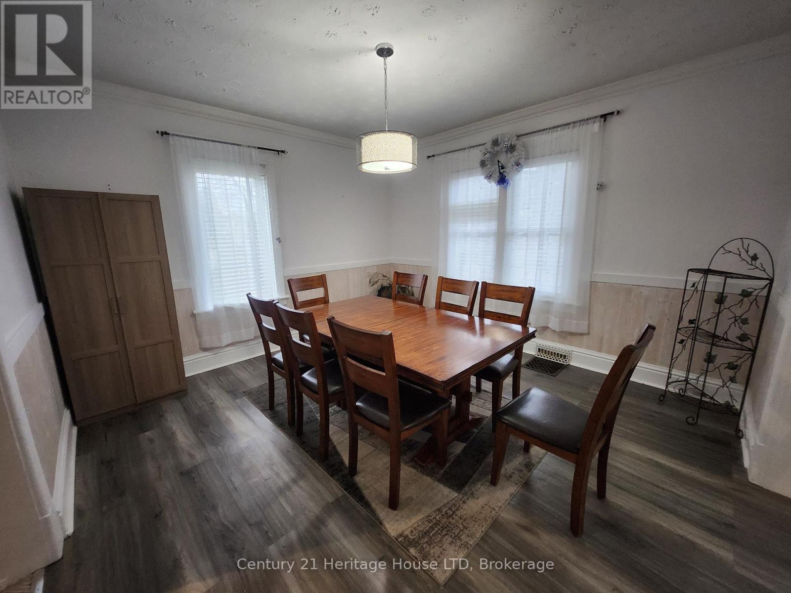A dining room with a wooden table and chairs.