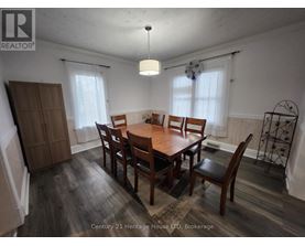 A dining room with a wooden table and chairs.