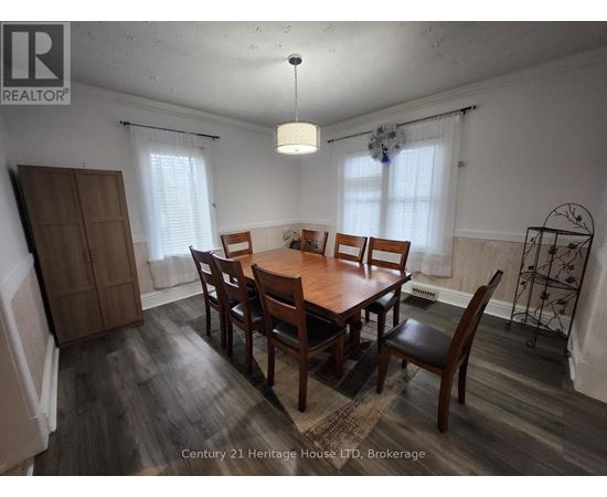 A dining room with a wooden table and chairs.