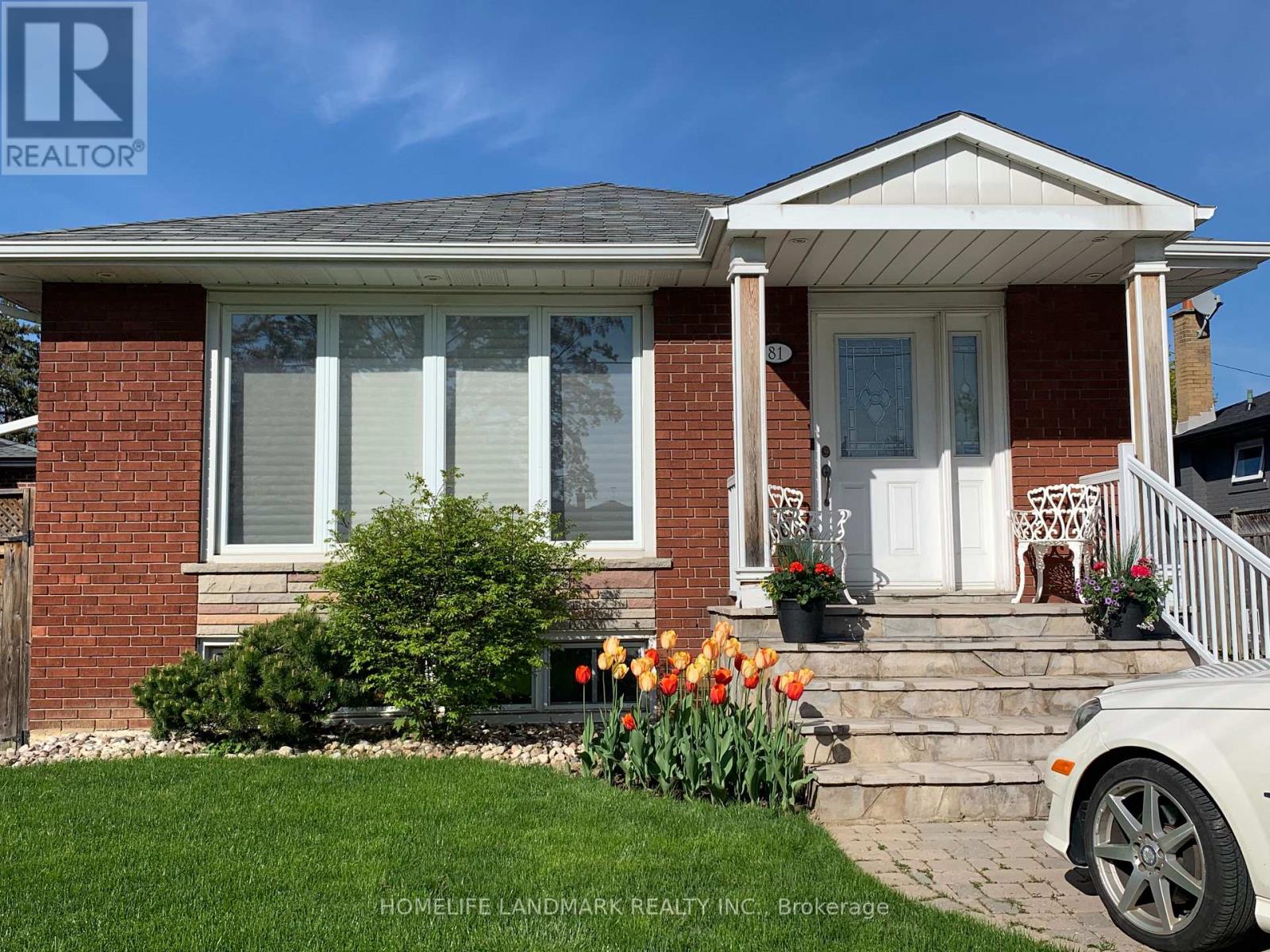 A house with a white porch and a white car parked in front.