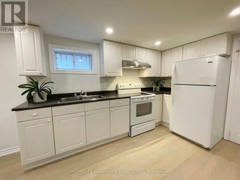 A kitchen with white cabinets and appliances.