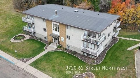 An aerial view of a two-story house with a grey roof and a brown door.