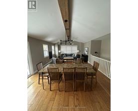 A dining room with a wooden table and chairs.