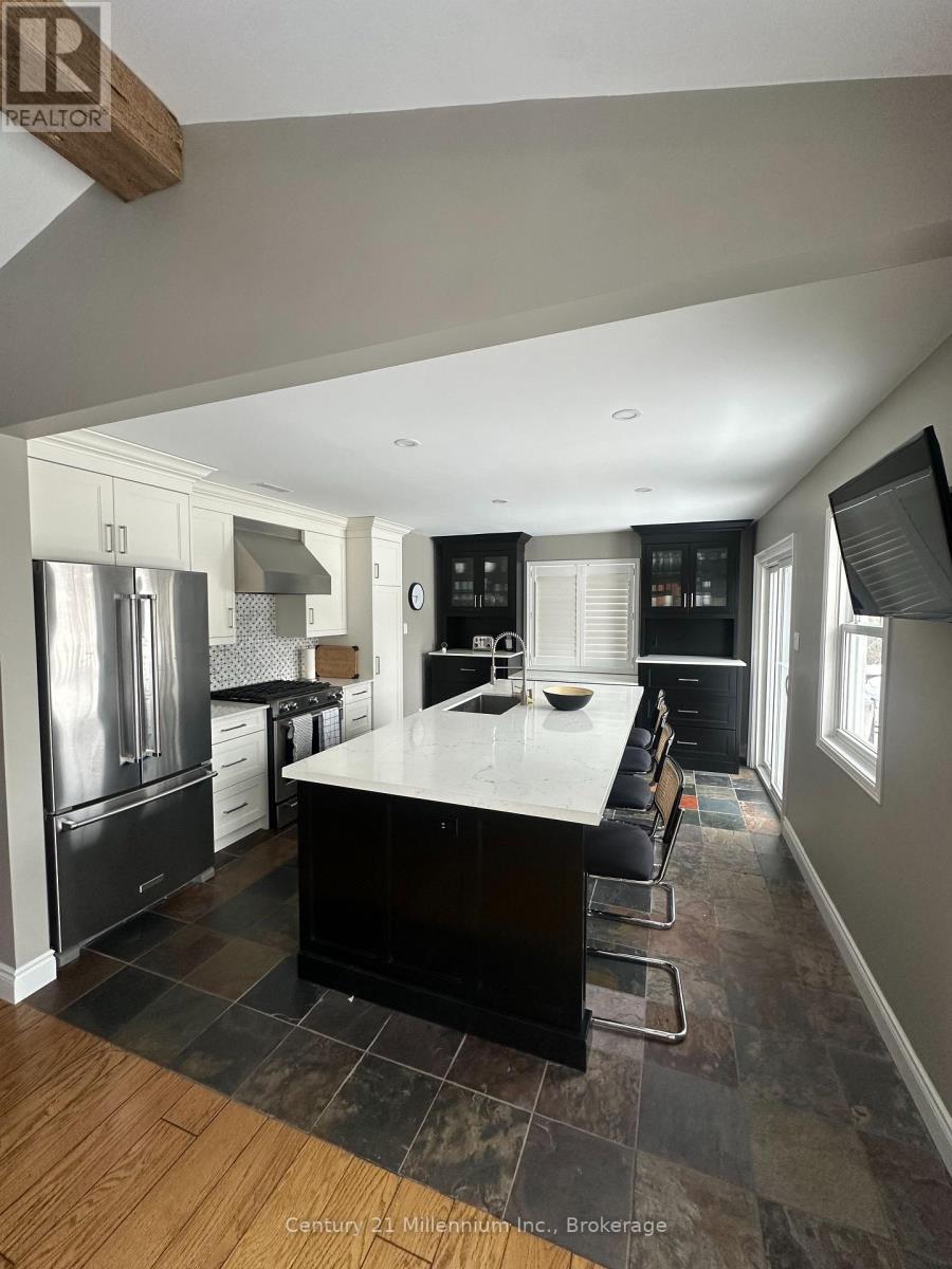 A kitchen with a black countertop and stainless steel appliances.
