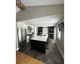 A kitchen with a black countertop and stainless steel appliances.