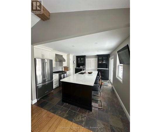 A kitchen with a black countertop and stainless steel appliances.
