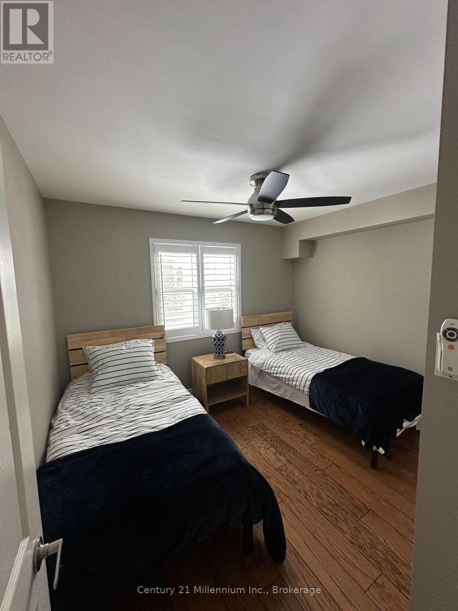 A bedroom with two beds and a ceiling fan.