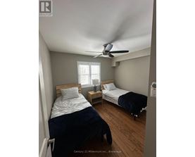 A bedroom with two beds and a ceiling fan.