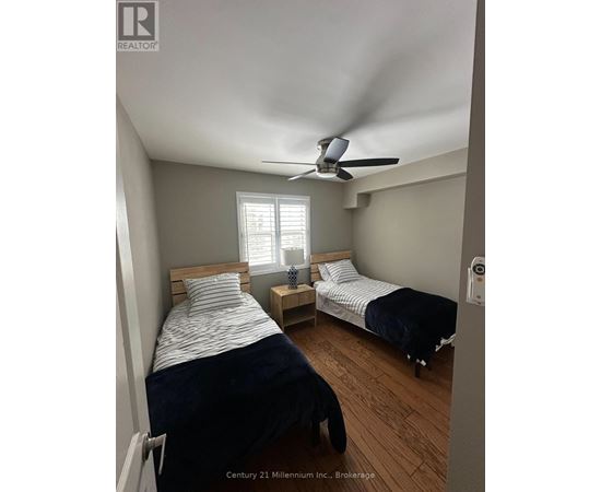 A bedroom with two beds and a ceiling fan.