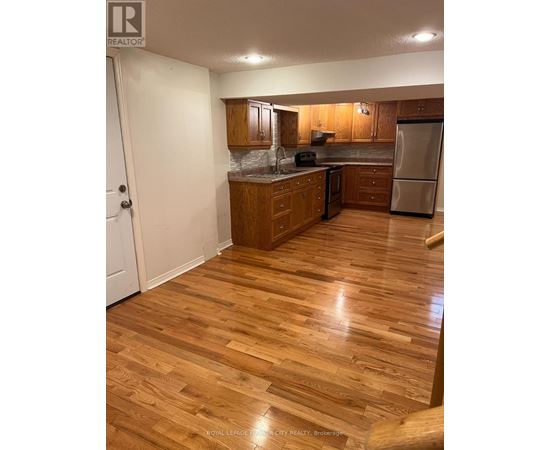 A kitchen with wooden floors and white walls.