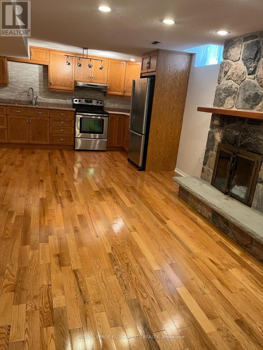 A kitchen with wooden floors and a stone fireplace.