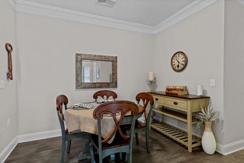 a dining room with a table and chairs and a clock