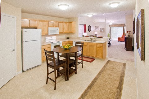 A kitchen with a table and chairs in the middle of the room.