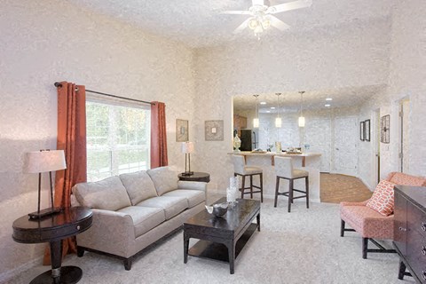 A living room with a couch, chairs, and a dining table.