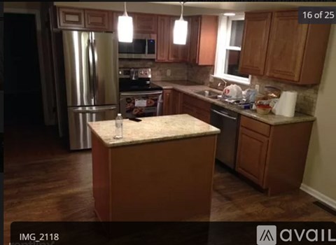 A kitchen with wooden cabinets and a granite island.