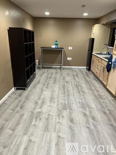 A kitchen with a wooden floor and a black cabinet.
