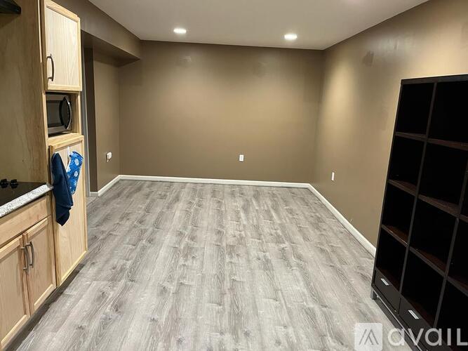 A spacious room with wooden cabinets and a grey floor.