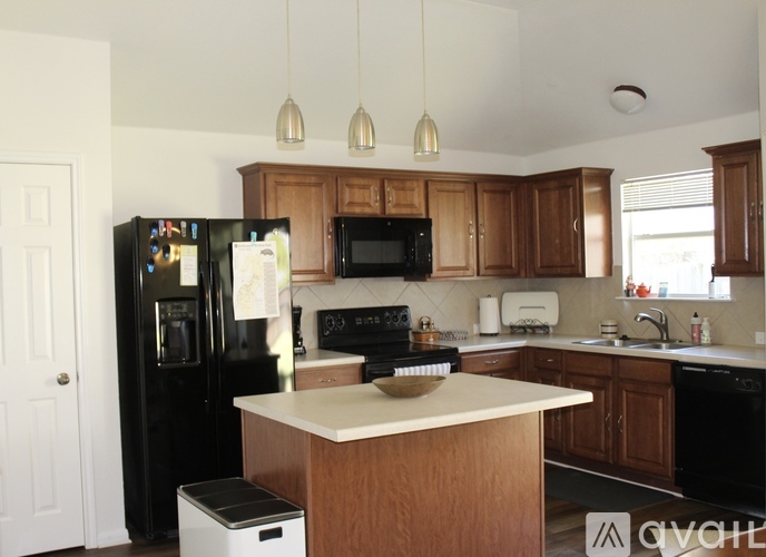 A kitchen with wooden cabinets and black appliances.