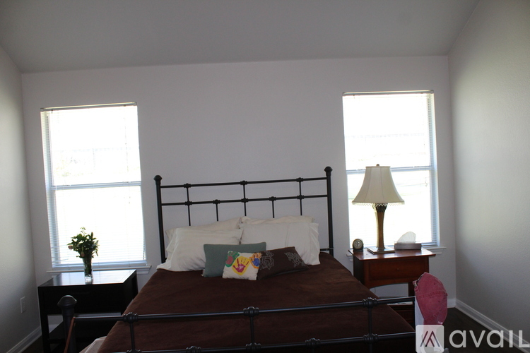 A bedroom with a bed, nightstand, and window.