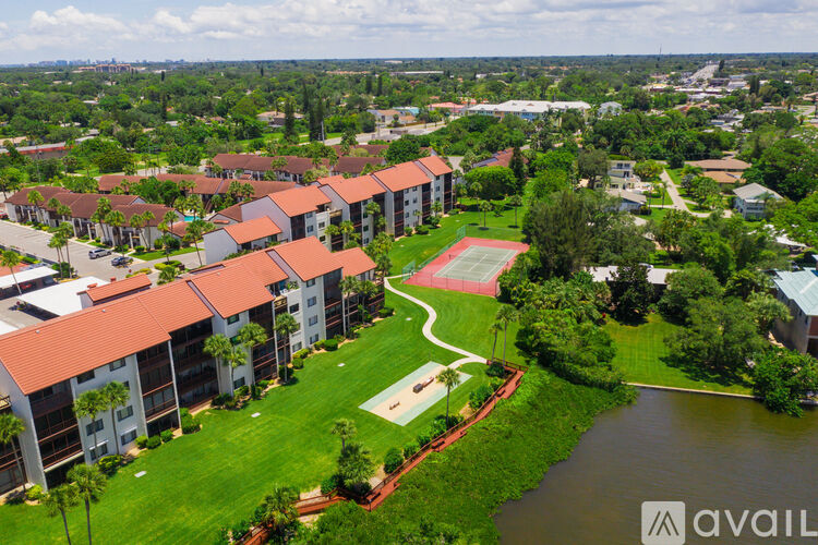 A bird's eye view of apartment buildings with a swimming pool and a river in the foreground.