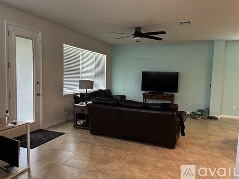 A living room with a brown couch and a flat screen TV.