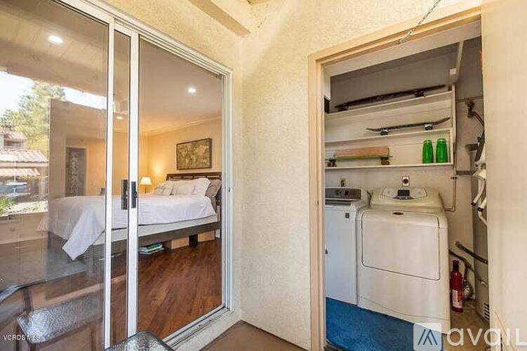 A bedroom with a washing machine in the closet.