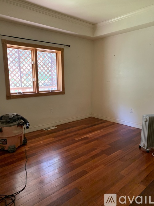 A room with wooden floors and a window with a wooden frame.
