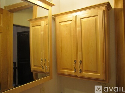 A kitchen with wooden cabinets and a mirror above them.