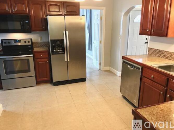 A kitchen with a refrigerator, oven, and microwave.