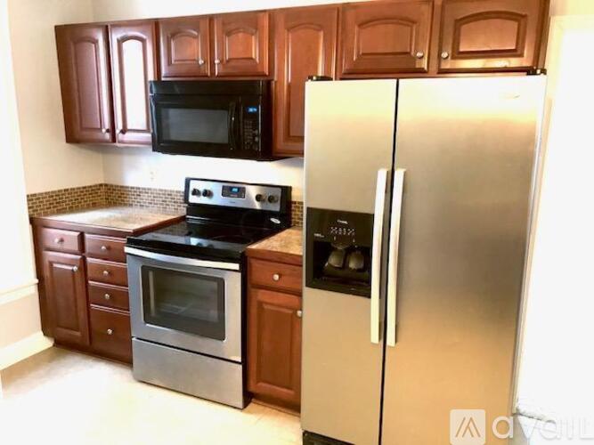 A kitchen with a stainless steel refrigerator, microwave, and oven.
