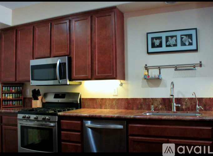 A kitchen with brown cabinets and a stove top oven.