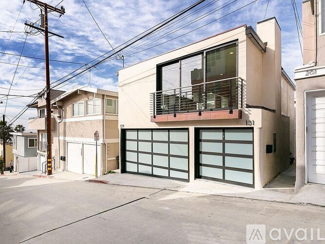 A two-story house with a garage door and balcony.