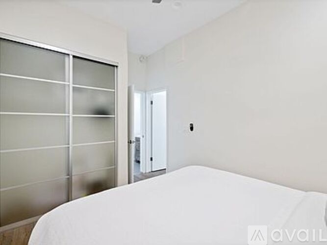 A bedroom with a bed, a wardrobe and a glass door.