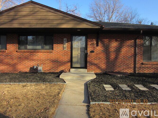 A brick house with a black door and windows.