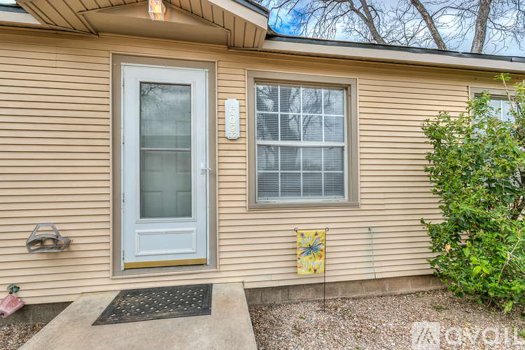 A house with a grey door and a window with a yellow flag on the wall.