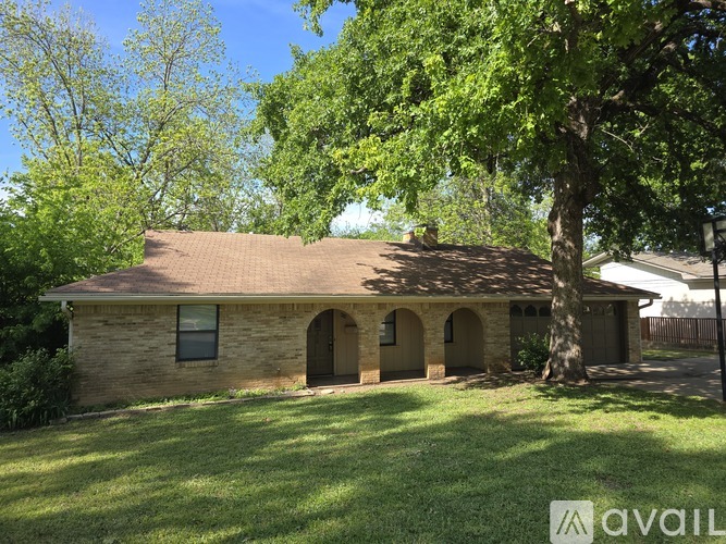 A house with a brown roof and a tree in front of it.