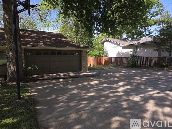 A residential area with a driveway and a basketball hoop.