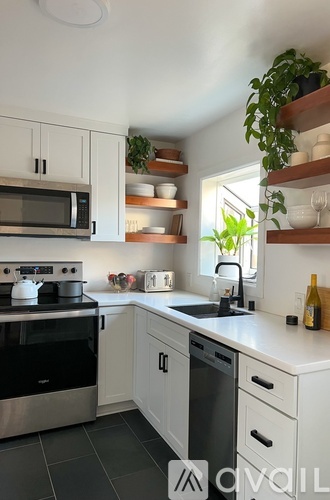 A kitchen with white cabinets and a black stove top oven.