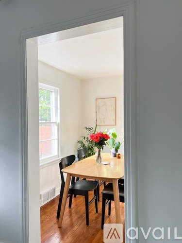 A dining room with a wooden table and chairs.
