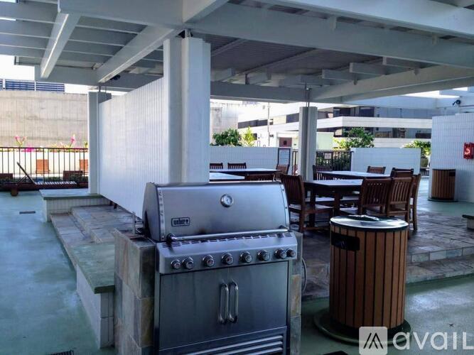 A BBQ grill is on a patio with a table and chairs.