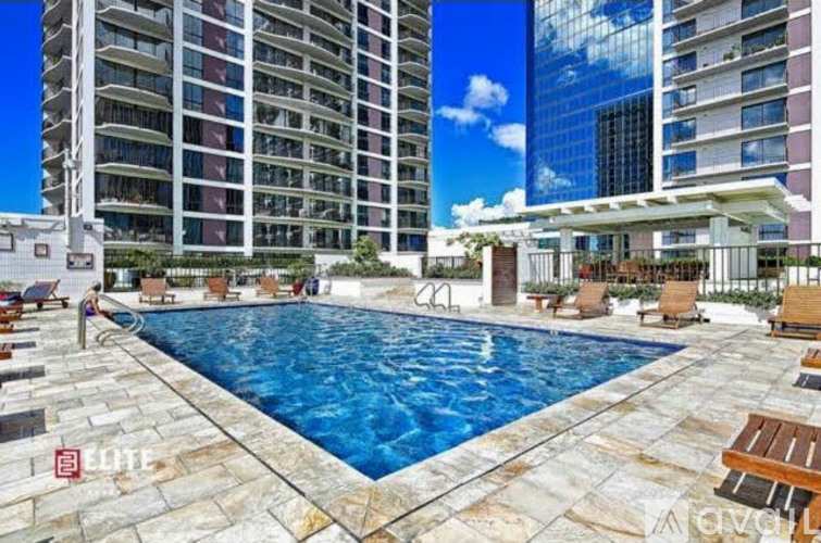 A swimming pool surrounded by lounge chairs and umbrellas in a residential area.
