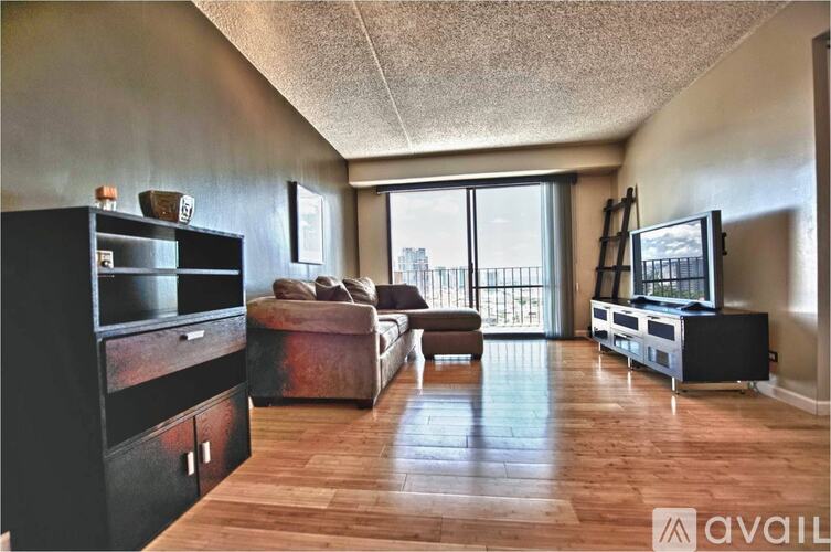 A living room with a brown sofa and a black entertainment center.