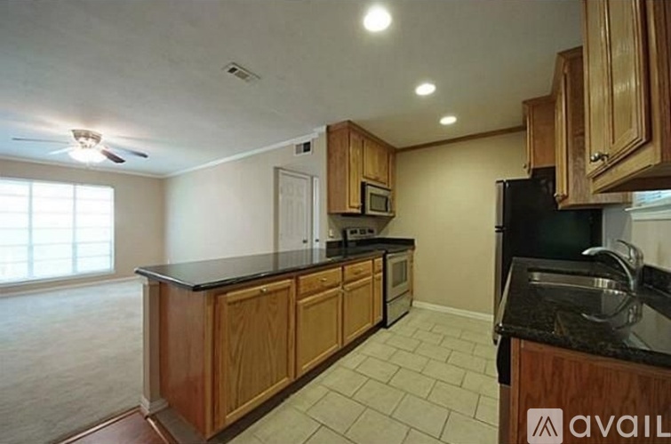 A kitchen with wooden cabinets and black appliances.