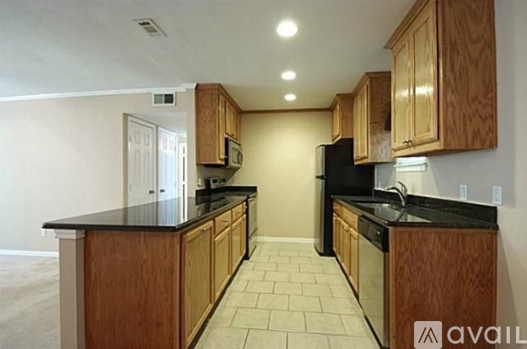 A kitchen with wooden cabinets and black countertops.