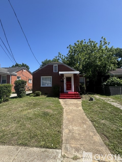 A red brick house with a white window and a metal railing.