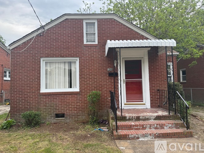 A red brick house with a white door and window.