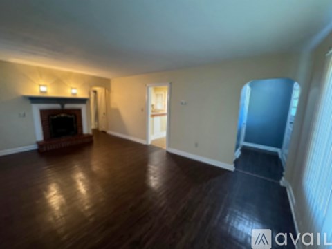 A living room with a fireplace and hardwood floors.