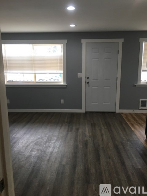A room with a white door and a window with blinds.