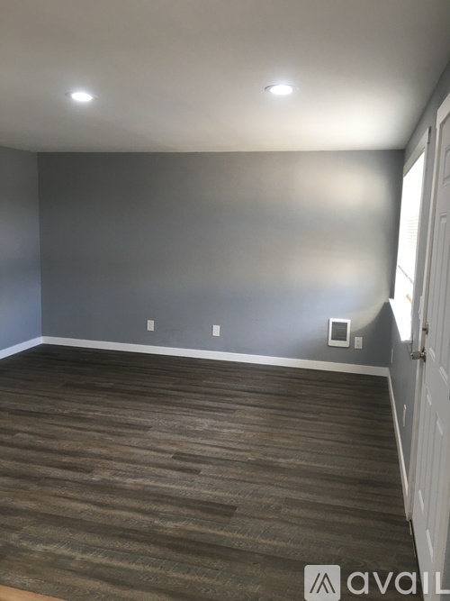 A room with a wooden floor and a white door.