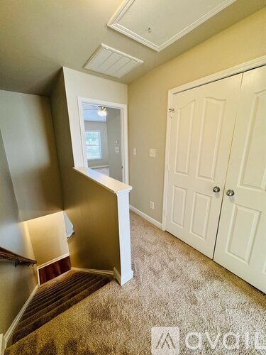 A carpeted stairway leads to a second floor bedroom.